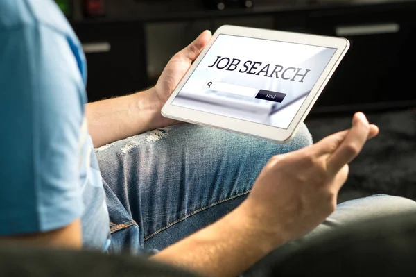 Happy job seeker trying to find work using online search engine home with tablet, Unemployment concept. Hopeful, motivated and excited man, fingers crossed. Jobseeker with positive attitude.