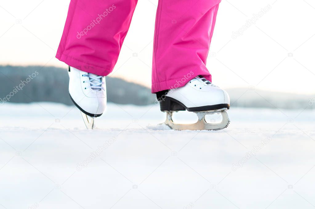 Girl skating on outdoor ice. Skater on frozen lake or pond. Young woman iceskating. Figure skating exercise or training. Fun winter activity in winter.