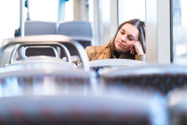 Tren veya otobüs üzgün yorgun kadın. Sıkılmış veya mutsuz yolcu tramvay el karşı yaslanmış oturuyor. Geç gecikmeli otobüste kızın canını sıkmak. Negatif toplu taşıma kavramı.
