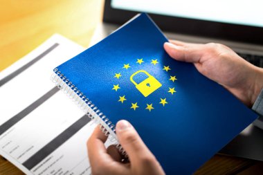 Gdpr (genel veri koruma yönetmeliği) kavramı. Avrupa Birliği (AB) bayrak logo ve kilit simgesi ile defter tutan işadamı. Dizüstü bilgisayar ve kağıt formu resepsiyon ve masa.