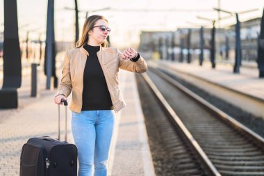 Time ve seyretmek mutsuz ve hayal kırıklığına uğramış kadın tren istasyonunda. Kızgın yolcu demiryolu platformu. Geç, geç, iptal edilen veya zamanlamanın gerisinde.