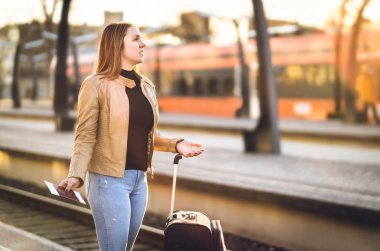 Sinir bozucu kadın tren istasyonunda. Geç, geç, iptal edilen veya programın gerisindeyiz. Mutsuz ve üzgün yolcu yanlış platformda kaybettim. Toplu taşıma ile sorun.