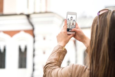 Tallinn, Estonya, Genç kadın fotoğrafta Alexander Nevsky Katedrali smartphone ile eski şehir. Gezi Fotoğrafçılığı ile hareket eden telefon.