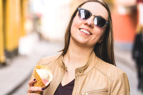 Woman with melted ice cream on nose. Happy smiling person eating melting icecream in the city. Messy face.