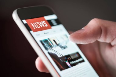 Cep haber uygulama smartphone içinde. Adam cep telefonu ile internet sitesinde online haber okuma. Son Makaleler internette tarama kişi. Telefon ekran ışığı.