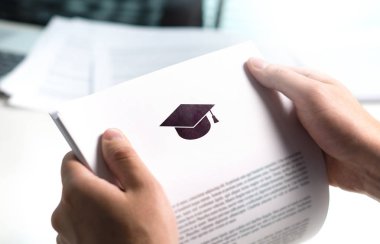 Kolej veya üniversite uygulama veya mektup okuldan. Öğrenci ya da öğretmen eğitim belge okuma. Genç adam tutarak grant, mezuniyet, çalışma kredi veya burs kağıt.