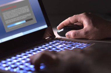 Yazılım yükleme laptop içinde karanlık geceleri dostum. Yasadışı program veya dosya indirme adam yükleme hacker. Siber güvenlik, korsan veya virüs kavramı.