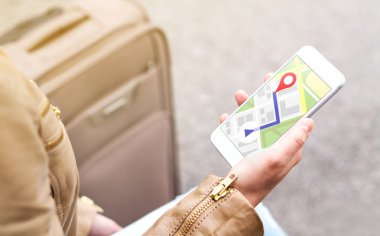 Turistik harita gezinmek ve şehirde Hotel'in lokasyonu bulmak içinde telefon app kullanarak. Ve kadın ile smartphone Gps hizmeti kullanarak Bagaj. Seyahat ve gezinti kavramı.