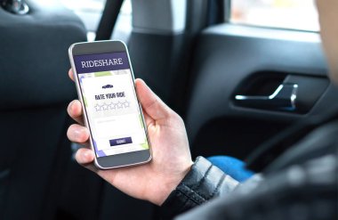 Paylaşım müşteri ve sürücü için derecelendirme vermek smartphone içinde rideshare uygulamasını kullanırken bir arabanın arka koltuğunda oturan yolcu binmek. Banliyö ve binici veren telefon taksi app gözden geçirin.