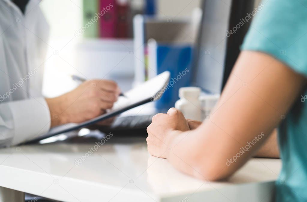 Sick patient visiting doctor in health care center or emergency room. Woman in appointment and meeting with physician or nurse. Specialist writing prescription to clipboard or notes to medical record.