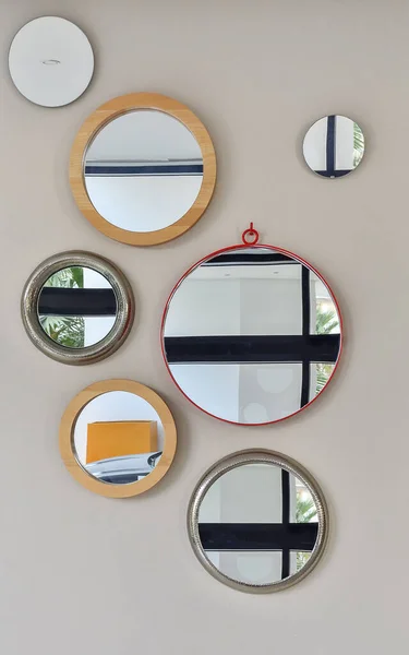 several round mirrors in a different setting on the wall in the room