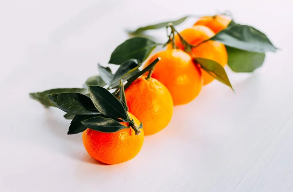 Five tangerines with green on a white background. Ripe orange fresh mandarin on a white background.