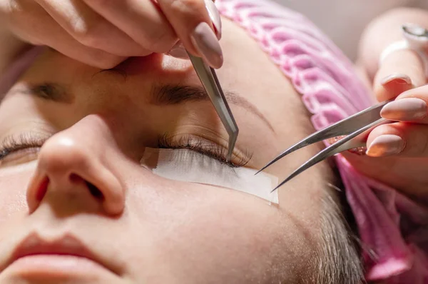 Eyelash extension procedure. Female eye with long eyelashes. Eyelashes, close-up, selective focus.