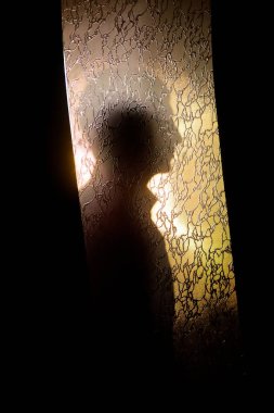 Bir adamın silueti kapının arkasında. Gizem ve belirsizlik.