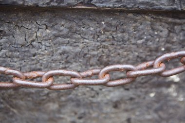 Çapa zinciri gri duvara doğru gerilmiş. Limanda eskrim yapmak için paslı metal.