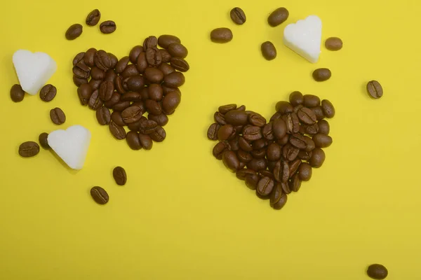 Szemes kávé, szív alakú, sárga háttér — Stock Fotó