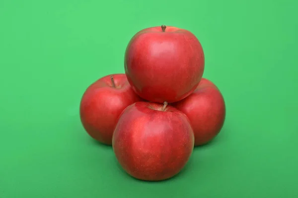 Vier rode appels op de groene achtergrond — Stockfoto