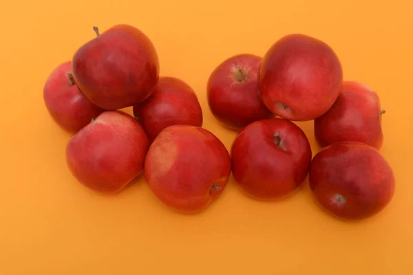 Dos Montones Manzanas Rojas Sobre Fondo Naranja — Foto de Stock