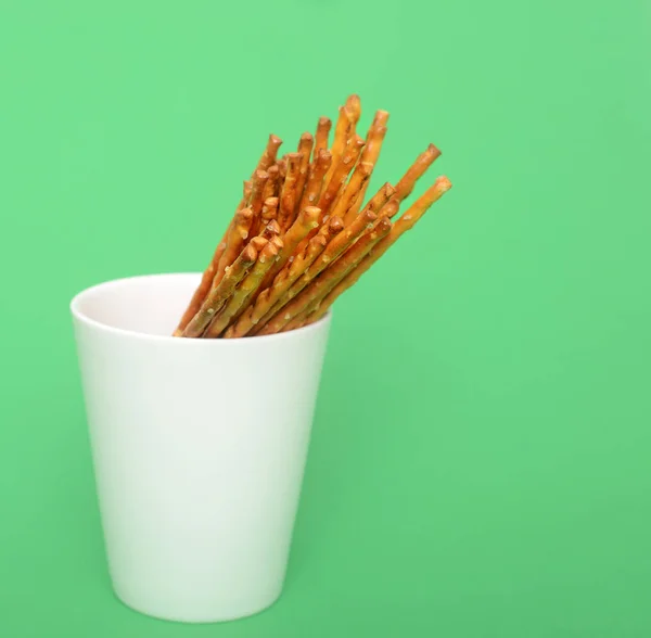 Montón Palos Salados Taza Blanca Sobre Fondo Verde — Foto de Stock