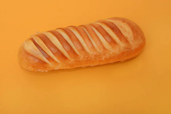 Foto de pão branco artesanal no fundo laranja — Fotografia de Stock