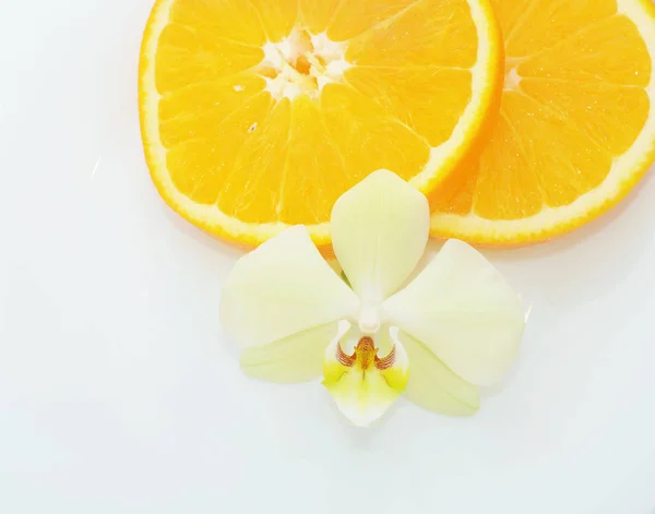 Blomma Orkidé Framför Apelsinskivor Vit Bakgrund Lukten Tropisk Frukt Apelsin — Stockfoto