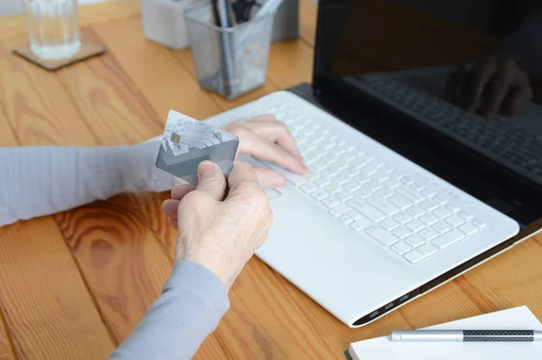 Anciana anciana usando laptop y sosteniendo tarjeta de crédito — Foto de Stock
