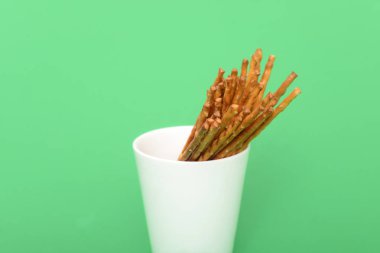 Beyaz bir bardak tuzlu sopa yığını