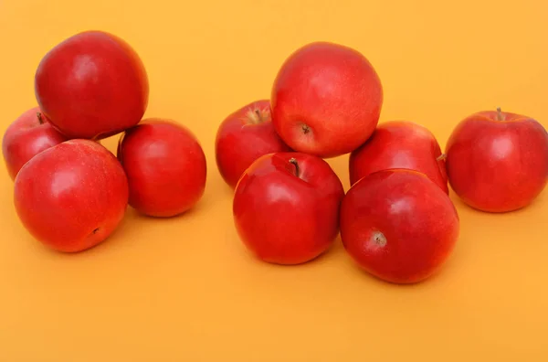 Two heap of red apples on a ornage background — Stock Photo, Image