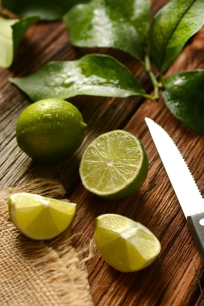 木製のテーブル 抗酸化作用をもつ熱帯性果物 クローズ アップの葉とライム果実 — ストック写真