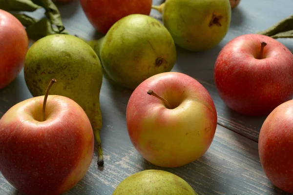 リンゴとライト ブルー木製テーブル クローズ アップの梨の山 — ストック写真