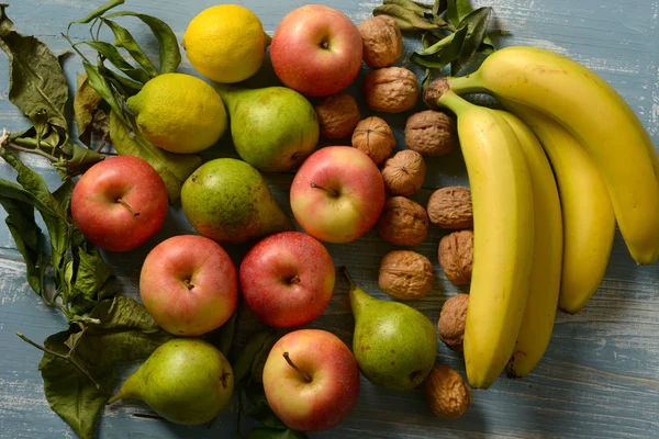Hromada Jablka Hrušky Ořechy Banány Světle Modré Dřevěný Stůl Detailní — Stock fotografie