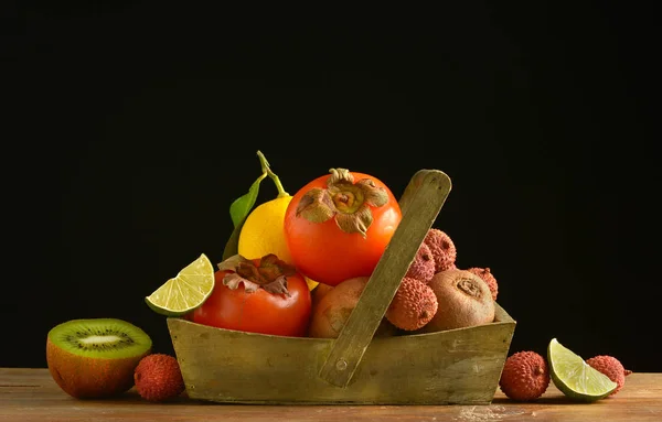 pile of exotic fruits on the black background - closeup