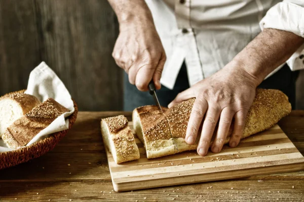 cut the bread on the wooden cutting board - eat healthy and traditional - selective focus - desaturated effect - closeup