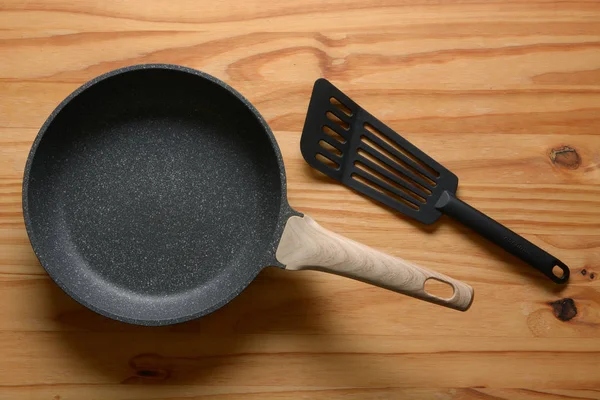 New non-stick frying pan on wooden table — Stock Photo, Image