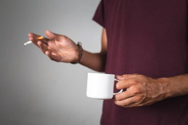 a person holding a coffee cup and a cigarette clipart