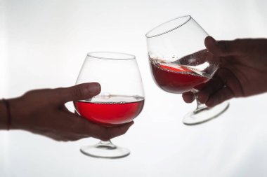 Şerefe! İnsanlar tezgahta kırmızı şarapla kadeh kaldırıyor.