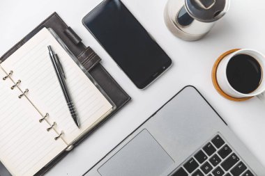 Akıllı telefon, dizüstü bilgisayar, not ve kahve fincanını kapat. İş ve işyeri kavramı. izole edilmiş bağımsız araçlar 