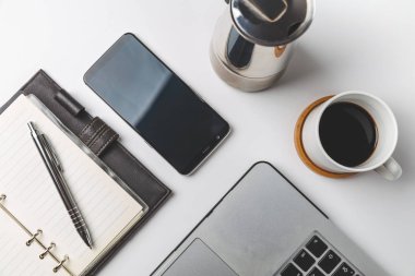 Akıllı telefon, dizüstü bilgisayar, not ve kahve fincanını kapat. İş ve işyeri kavramı. izole edilmiş bağımsız araçlar 