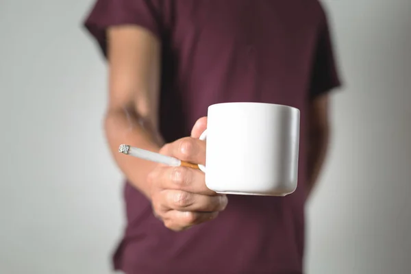 Una persona in possesso di una tazza di caffè e una sigaretta — Foto Stock