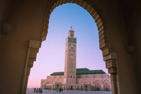 Büyük bir kapının kemeriyle çerçevelenmiş 2. Hasan Camii manzarası