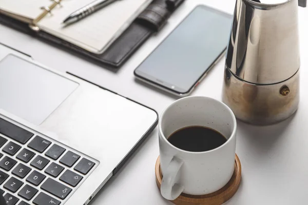 close up of smartphone, laptop, note and coffee cup . business and workplace concept . isolated freelancer tools