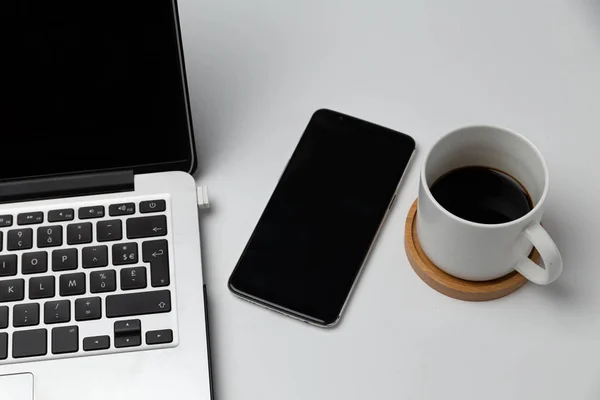 Akıllı telefon, dizüstü bilgisayar, not ve kahve fincanını kapat. İş ve işyeri kavramı. izole edilmiş bağımsız araçlar 