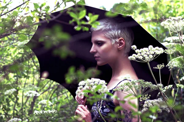 草原で傘を持って若いブロンドの女の子の肖像画 — ストック写真
