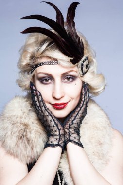 Retro tüyler ve dantel eldiven ile şapkalı bir kız portresi