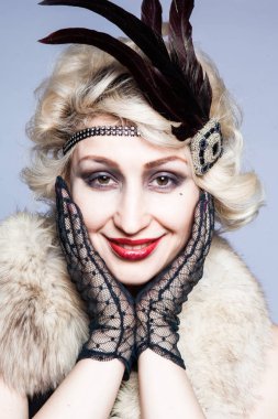 Retro tüyler ve dantel eldiven ile şapkalı bir kız portresi