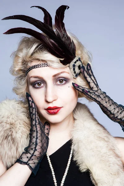 Retro portrait of a girl in a hat with feathers and lace gloves