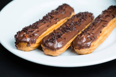 Bir tabakta çikolata krema ile Eclairs