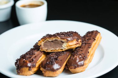 Bir tabakta çikolata krema ile Eclairs