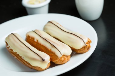Bir tabak üzerinde beyaz krema ile Eclairs