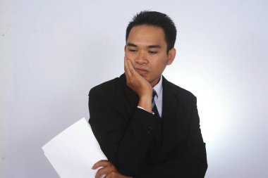 Üzgün Asya iş adamı eliyle yüzünü kaplı